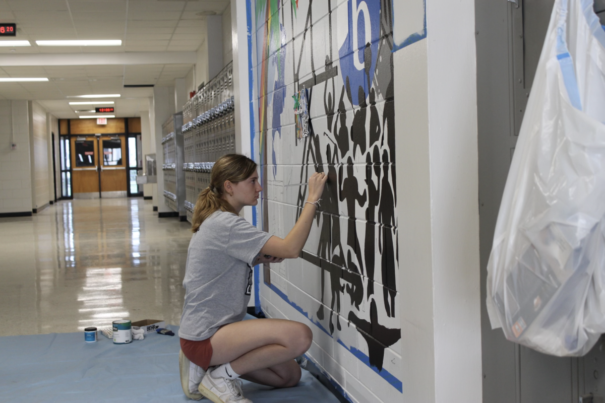 Millay Kral (24) works on her mural located in the science building.  